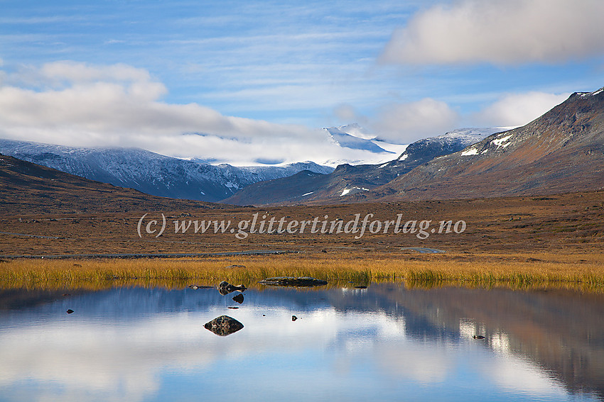 Stemningsfull høstdag i Veodalen ved Bergenusstjønne. I bakgrunnen titter Nørdre Styggehøbreatinden og Søre Veotinden frem fra skyene.