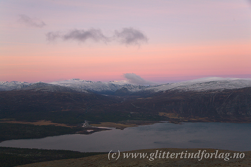 Fra Trollhøe (1370 moh.) med utsikt innover i Jotunheimen en grytidlig høstmorgen. I forgrunnen Tesse med Smådøla som kan følges innover Smådalen. I bakgrunnen Jotunheimens tindeverden med bl.a. Kvitingskjølen helt til høye og Glittertinden relativt sentralt.