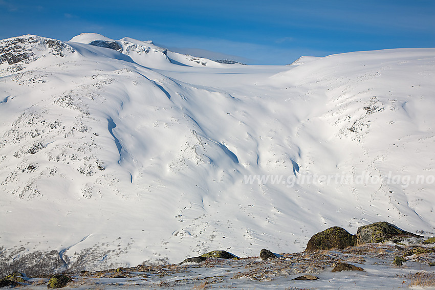 Fra dalbrekket nedenfor Skautflye ut mot Visdalen. På motsatt side av dalen ses fjellsiden opp mot Styggebrean med Svellnose, Keilhaus Topp og Galdhøpiggen i bakgrunnen.