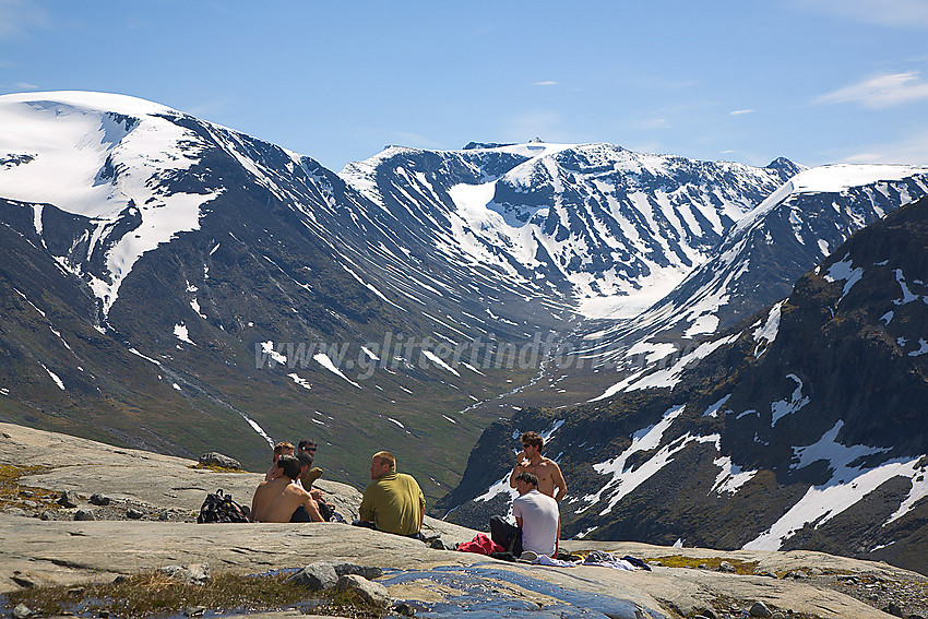 Pause på svabergene nedenfor Svellnosbrean med Leirhøe og Memurutindane i bakgrunnen.