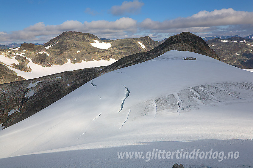 Fra sadelen mellom Uranostinden og Slingsbytinden mot øvre del av Skogadalsbreen med Uraknatten bak. Bak til venstre ses Mjølkedalspiggen (2040 moh).