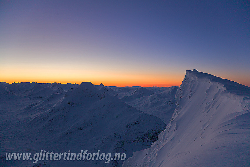 Like nord for Gravdalstinden med toppen (2113 moh) til høyre i bildet. Sentralt i bildet ses silhuetten av Store Rauddalstinden (2157 moh).