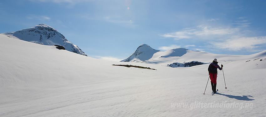 Skiløper på vei innover Simledalen med Midtre Høgvagltinden (2066 moh) til venstre og Austre Rauddalstinden (2086 moh) bak i midten.