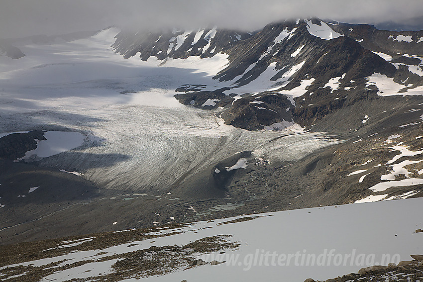 På vei ned fra Surtningssue mot Austre Memurubrean. Til høyre i bildet ligger Memurutinden Ø2 under tåke helt ytterst på fjellryggen.