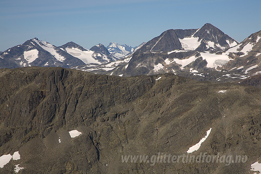 Fra sørryggen på Surtningssue mot Raudhamran i forgrunnen (1893 moh). Bak til høyre ses Semeltinden (2236 moh) med Skarddalseggje (2159 moh) og Skarddalstinden bak til venstre. I det fjerne skimtes Hurrungane.