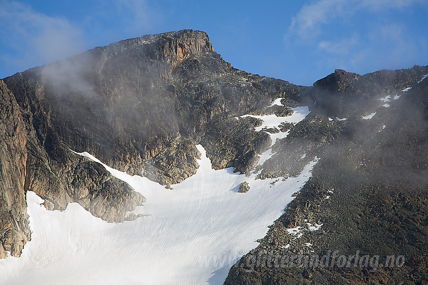 Surtningssue Sørtoppen (2302 moh) sett fra sørryggen. Sørtoppen har en forholdsvis krevende vegg på østsiden som man ser som en bratt hammer øverst mot toppen. Til skaret til høyre for toppen er det imidlertid greit å ta seg opp via breen og senere på ur og litt klippeklyvinf.