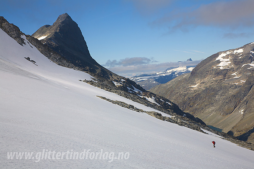 Liten person på vei opp mot Koldedalstinden. Hjelledalstinden (1989 moh) i bakgrunnen. I det fjerne skimtes Store Austanbotntinden.