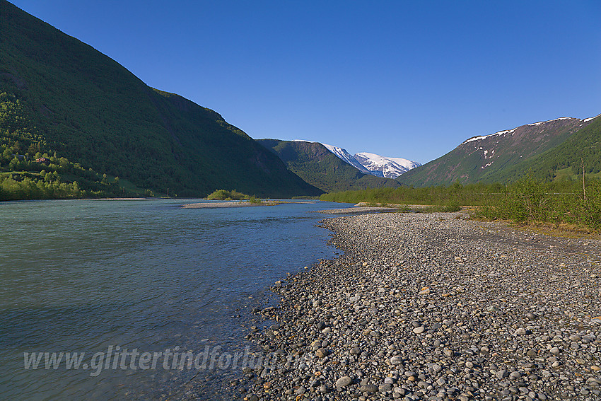 I Bøverdalen en forsommerdag mot snøkledde tiner i bakgrunnen. Hhv. Galdhøfjellet (delvis tildekket) og Storgrovhøe.