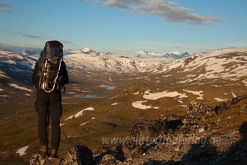 På dalbrekket over Veodalen på vei mot Trollsteinkvelven. I bakgrunnen Veodalen mot et ennå snøhvitt teppe av tinder. Herunder bl.a. Surtningssue, Styggehøbrea- og Veotinder.