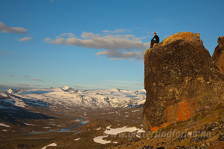 Pause på en stor stein høyt over Veodalen med bl.a. Surtningssue i bakgrunnen.