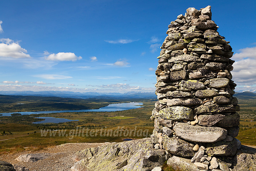 Varden på toppen av Synhaugen (1085 moh) med Yddin i bakgrunnen. Ser du den vesle figuren som står oppstilt på en stein i varden?