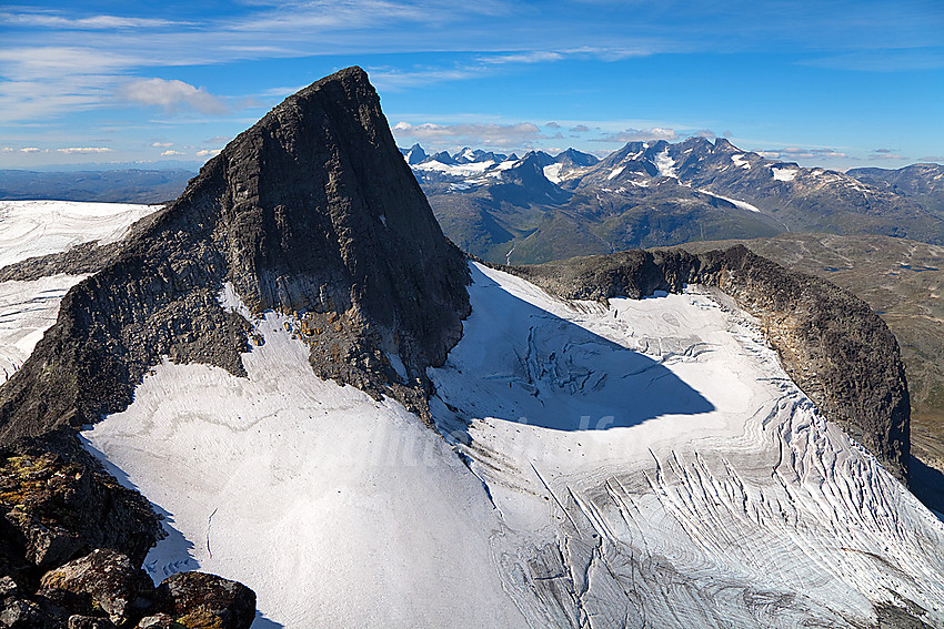 Fra Midtre Stølsnostinden mot Stølsnostinden (2074 moh) med Stølsnosbreen ned til høyre. Hurrungane i bakgrunnen.