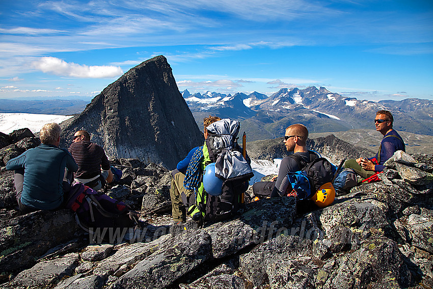 Pause på toppen av Midtre Stølsnostinden med Stølsnostinden (2074 moh) og Hurrungane i bakgrunnen.