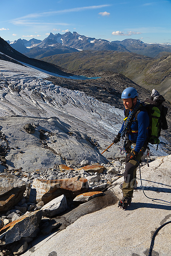 Pause på svaberget i kant av Stølsnosbreen. I bakgrunnen ruver Hurrungane.