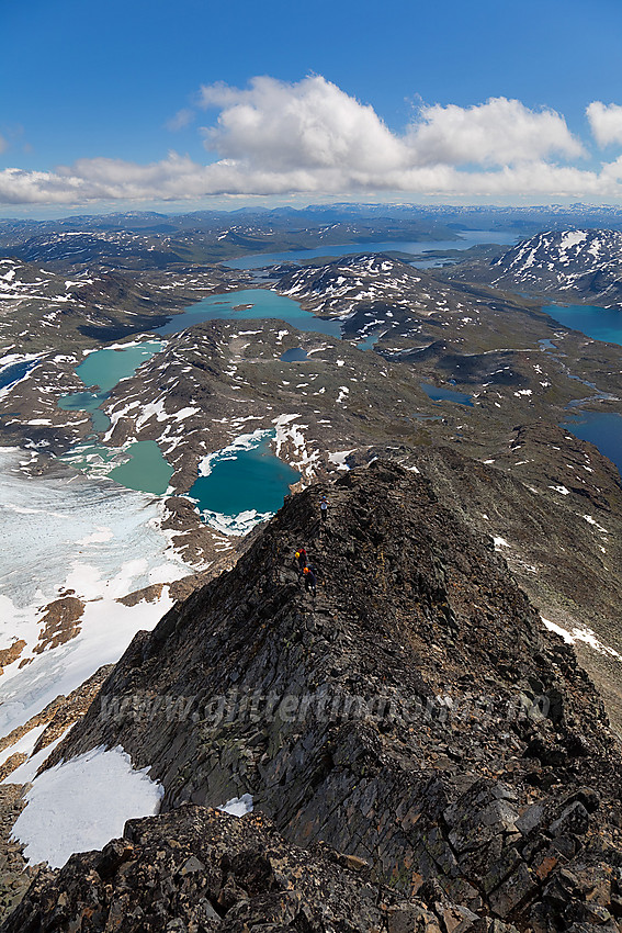 Fjellvandrer på vei opp mot Uranostinden S2 (2048 moh). Uranosbreen nede til venstre og i bakgrunnen bl.a. Kvitevatnet og Tyin.