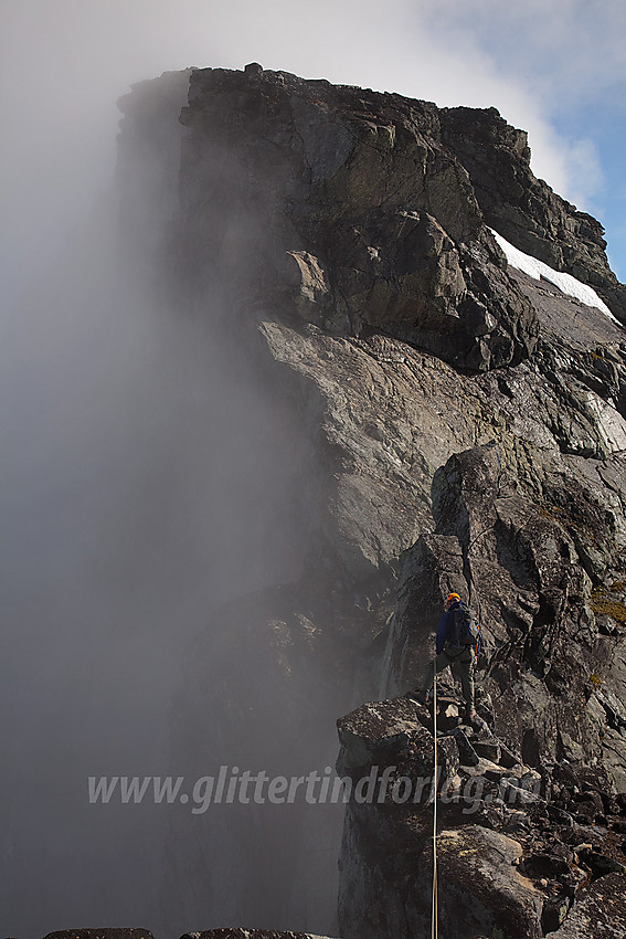 Fra sørligste Austanbotintinden mot den vesle pinakkelen (går nesten i ett med bakgrunnen) og Søre Austanbotntinden (2103 moh). Klamme morgengretne tåkeskyer klamrer seg ennå til fjellsidene mens sola jobber med å gjøre kål på dem.