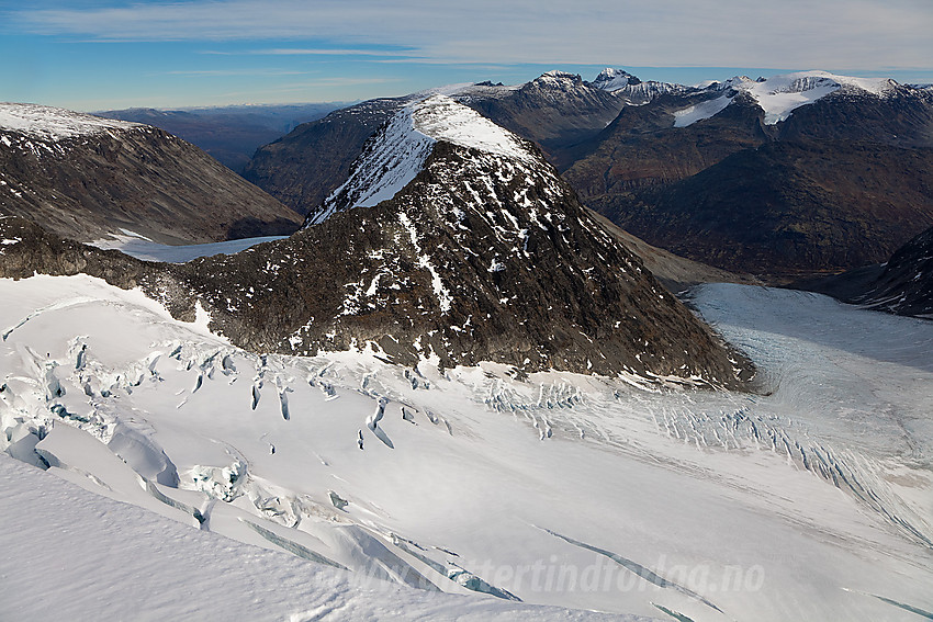 Fra Veslbreatinden mot Bakarste Skagsnebb (2093 moh). Veslbrean, rik på sprekker, i forgrunnen. I bakgrunnen ses bl.a. Skardstinden, Galdhøpiggen og Bukkehøe.