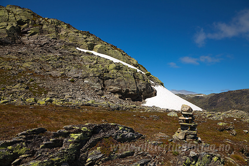 Vardet rute fra Rysndalen mot Mjellknapp. Her ved den bratteste biten, oppgangen i bakgrunnen hvor stien går opp i høyre kant av fjellskrenten i bakgrunnen.