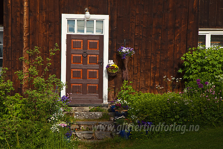 Blomsterdekorert fasade på nabobygget til Lomen Stavkirke.