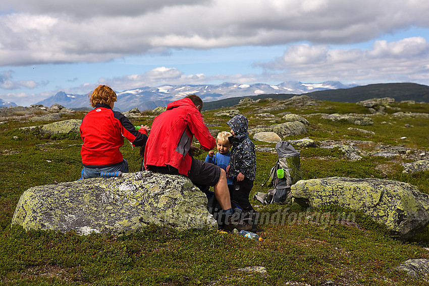 Barnefamilie på toppen av Brummknappen (1150 moh). Jotunheimen i bakgrunnen.