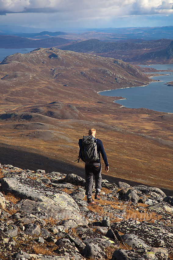 Fjellvandrer på vei ned fra Nørdre Kalvehølotinden mot Bygdin som ses i bakgrunnen.