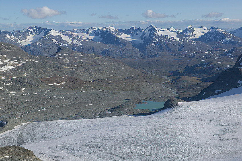 Fra Memuruskardet med utsikt i sørlig retning. I forgrunnen fronten på Austre Memurubrean etterfulgt av Memurudalen med Muruelva. I bakgrunnen de flotte Gjendealpene.