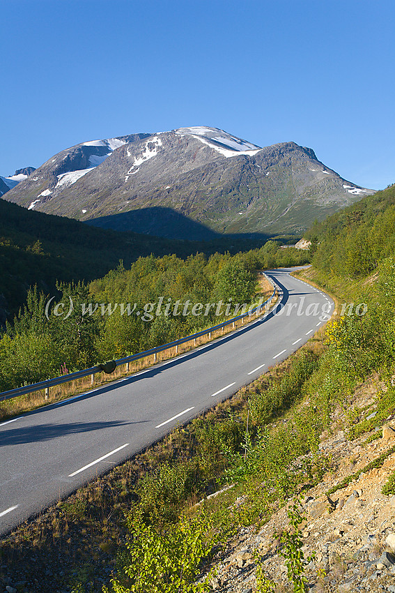 Sommermorgen i Leirdalen ved riksvei 55, like nedenfor avkjøringen mot Leirvassbu. I bakgrunnen dominerer Loftet (2170 moh.) med Veslloftet som et fremspring til høyre.