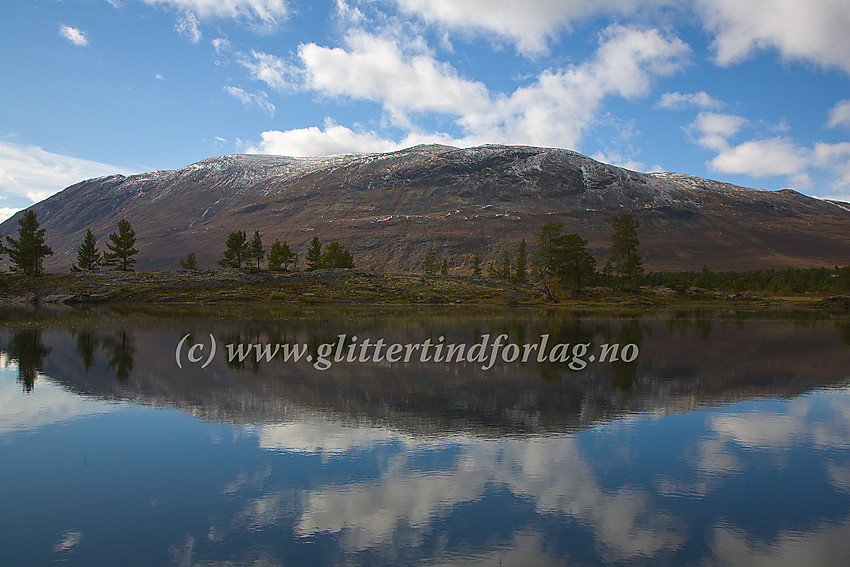 Et blikkstille Tesse ved Tessosen i nordenden med Tessefjellet i bakgrunnen.