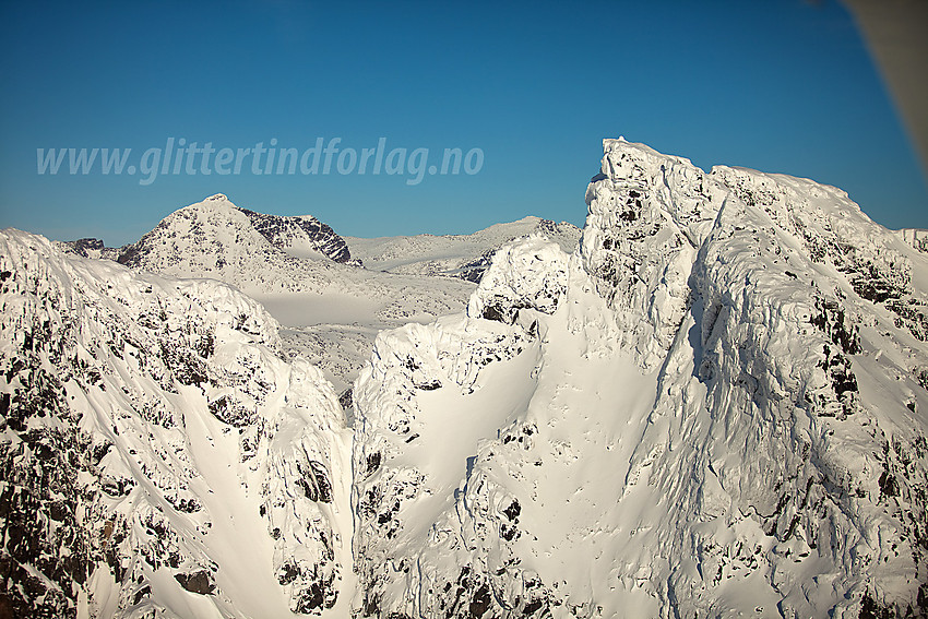 Vestre og Midtre Torfinnstinden med Austre Leirungstinden i bakgrunnen. På bildet ser man tydelig de tre hamrene vest for Midtre Torfinnstinden.