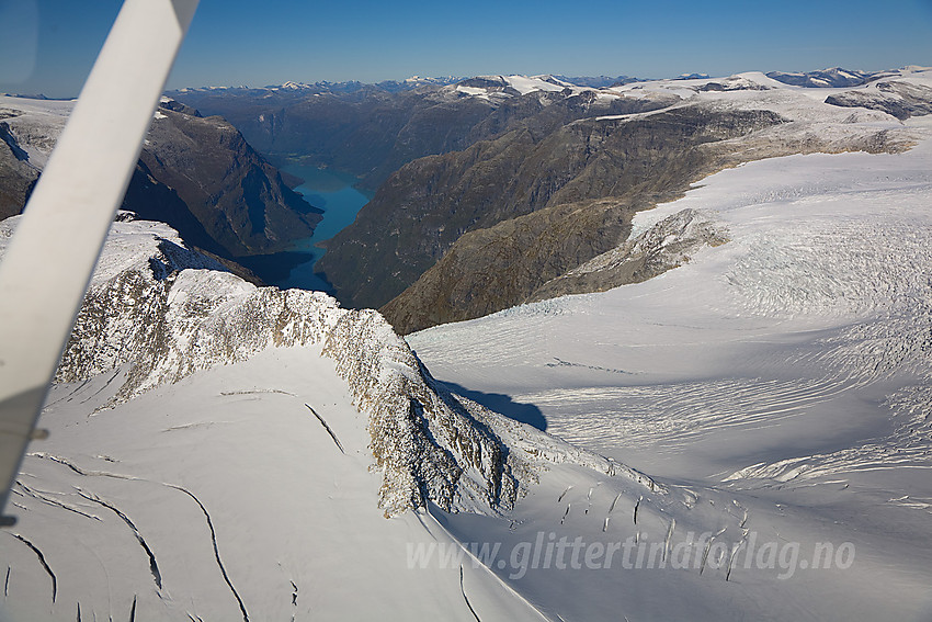 Vi flyr utover mot Kjenndalskruna med Krunebreen til høyre og Bødalsfjellet bakenfor. Lenger bak ses Lovatnet.