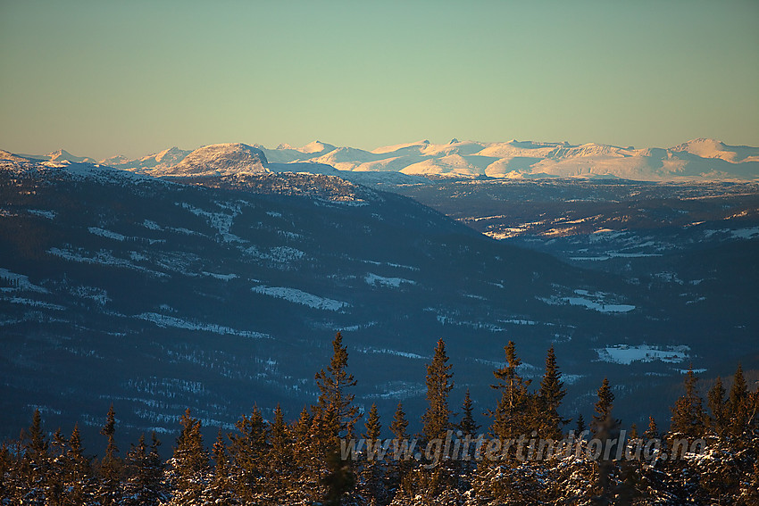 Fra Dalavardin med telelinse mot Etnedal oppover til Rundemellen og videre mot Jotunheimen.