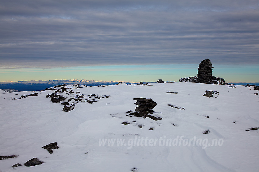 På toppen av Besshøe. I det fjerne glitrer solskinnet over Rondane.