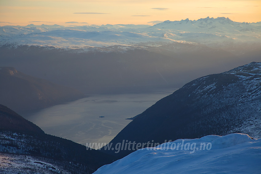 Morgenstemning på Stora Grånosi med en tidlig morgenferge på strekningen Fodnes-Mannheller nede på fjorden. Bak til høyre de takkede Hurrungane i Vest-Jotunheimen.