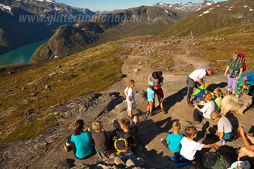 Barnas Turlag på vei mot Besseggen. Her en pause på vei opp bakkene fra Memurubu. I bakgrunnen Memurutunga.