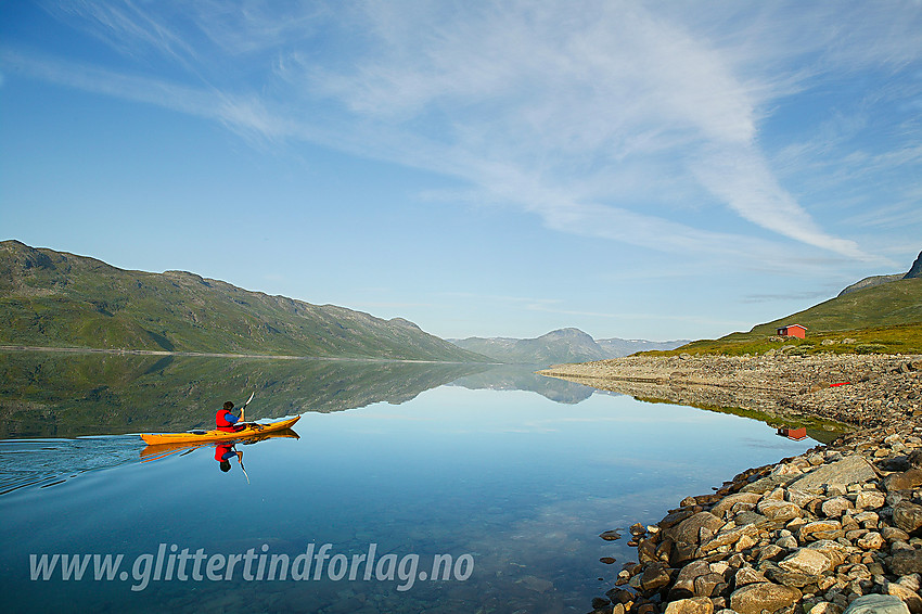 Padling på et blikkstille Bygdin nær Nybue (ved foten av Torfinnstindane) som ses i bakgrunnen til høyre.