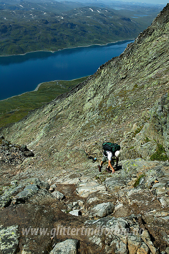 På vei opp i midtre del av "normalrenna" mot Øystre Torfinnstinden. I bakgrunnen Bygdin sentralt med Vølohornet bak til høyre. Renna er ikke veldig bratt, men litt småklyving er det innimellom.