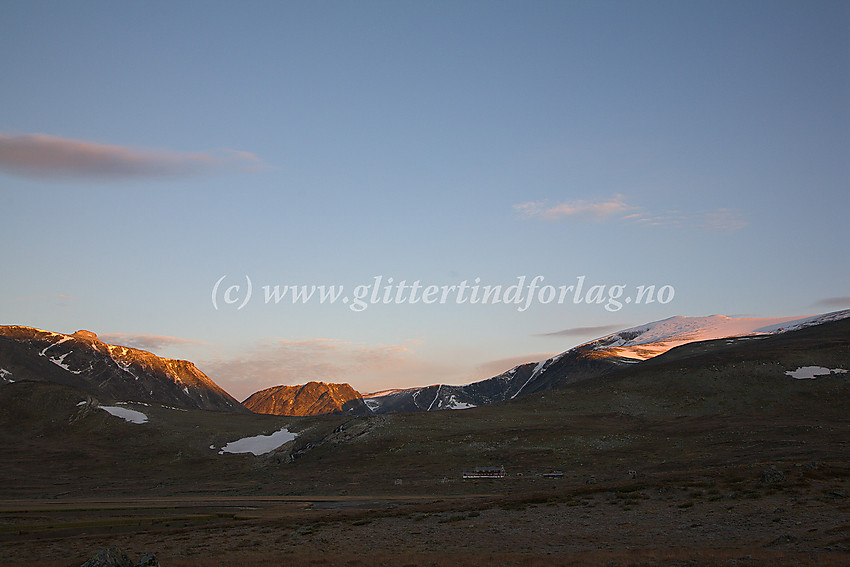 Høstmorgen i Veodalen. Glitterheim ligger i morgenskyggen mens solstrålene allerede har funnet veien til Steinbukampen (1997 moh) og Glittertinden (2464 moh).