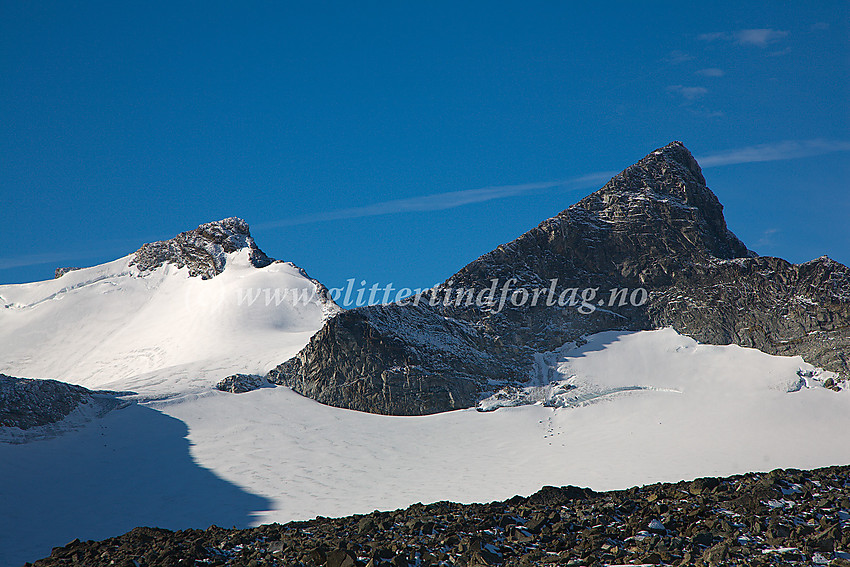 En krystallkar høstdag mot Søre (2267 moh) og Store (2240 moh) Veotinden sett fra nord. Styggehøbrean ligger oppunder begge toppene og til venstre i bildet ses et lite band som forbinder de to armene av Styggehøbrean. Her er det knapt is igjen, men en lumsk bregleppe på nedsiden.