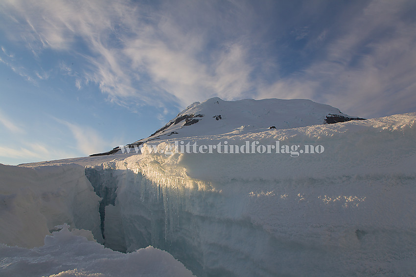 Ved en stor bresprekk på Kerckhoffbreen. Beerenbergmassivet i bakgrunnen.