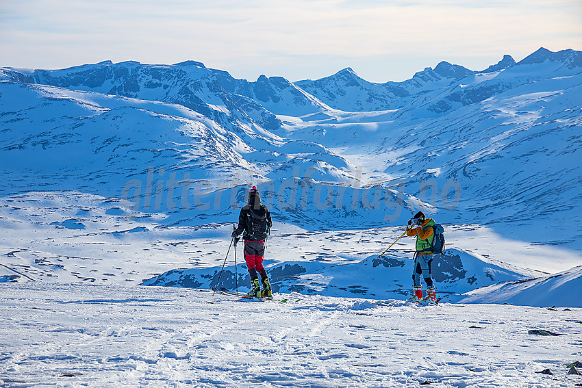 Skikjørere på toppen av Heimdalshøe en vårkveld. Leirungsdalen og Gjendealpene i bakgrunnen.