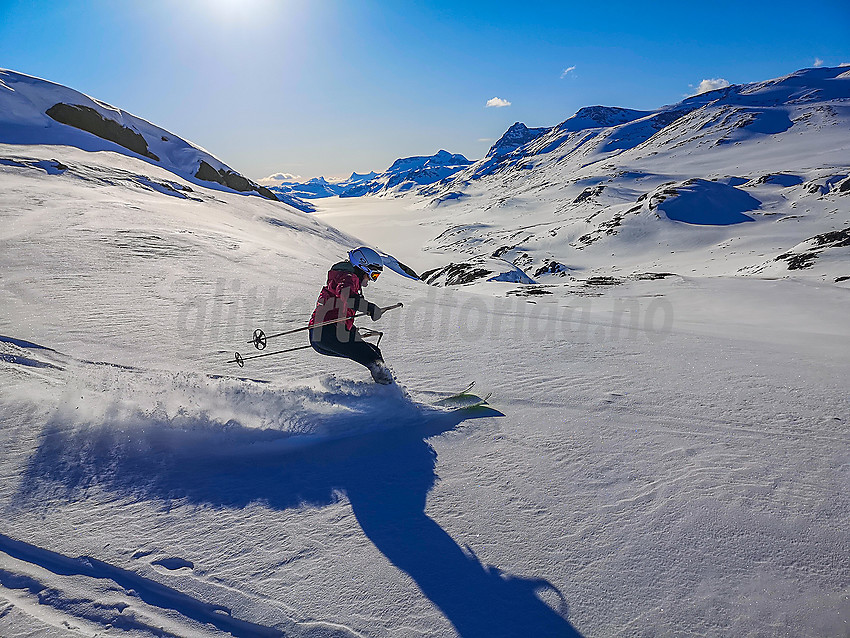 Skikjøring på baksiden av Kongsliknuppen. Bygdin og Jotunheimen i bakgrunnen.