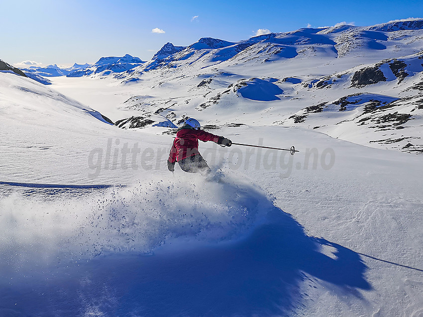 Skikjøring på baksiden av Kongsliknuppen. Bygdin og Jotunheimen i bakgrunnen.