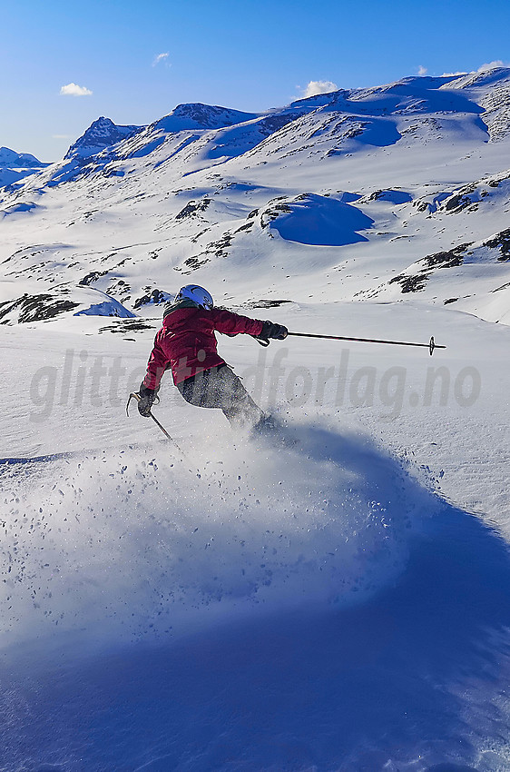 Skikjøring på baksiden av Kongsliknuppen. Bygdin og Jotunheimen i bakgrunnen.