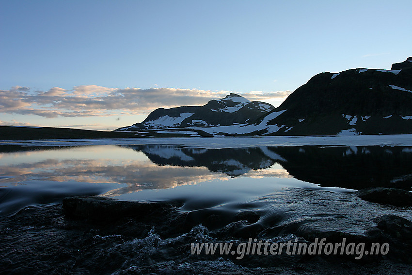 Galdebergtinden (20275 moh) speiler seg i Langedalstjernet. I forgrunnen begynner Langedalsåne på sin ferd ned mot Bygdin.