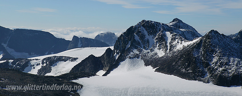 På nord-nordvestryggen til Tjønnholstinden med utsikt sørvestover mot Skarvlyløyfttinden og Søre Skarvflytinden. Litt bakenfor ruver Austre Leirungstinden. I bakgrunnen til venstre ses bl.a. Vestraste Kalvehøgde, Leirungskampen og Øystre Torfinnstinden.