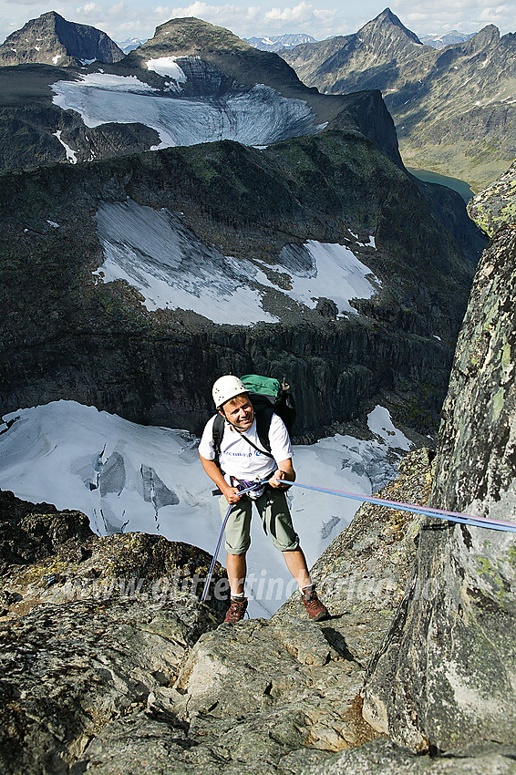 1. rappell fra Midtre Torfinnstinden mot vest. I bakgrunnen er det langt ned til Torfinnsbreen. I bakgrunnen ses Mesmogtinden, Kvitskardtinden og Store Knutsholstinden, for å nevne noe.