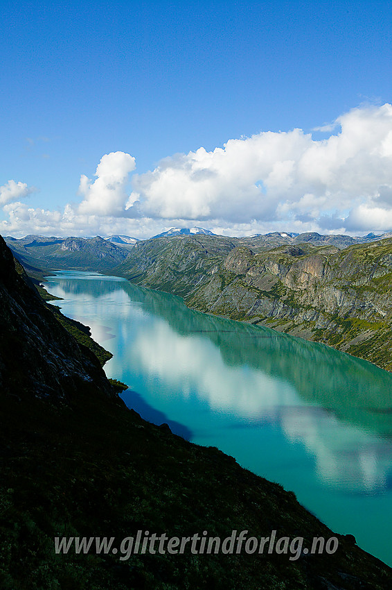 Utsikt fra Memuruhåmåren vestover Gjende. På høyre side av vannet strekker Memurutunga seg innover. I bakgrunnen ses bl.a. Gjendetunga og Snøholstinden.