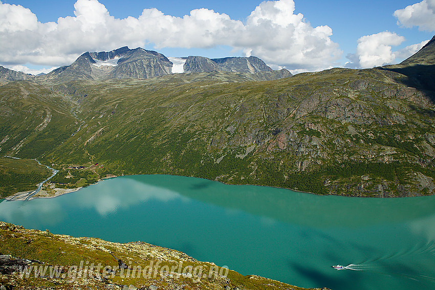 Utsikt fra Memuruhåmåren mot Gjende, Memurubu og Surtningssue. Nede på vannet ses Gjendine på vei til Memurubu.