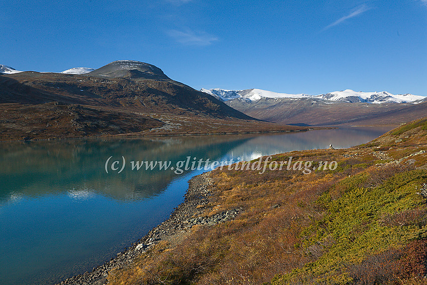 Ved nordbredden på Russvatnet mot Kollhøin og Grotodden. I bakgrunnen ses Surtningssumassivet (2368 moh) og Styggehøbreatindane (2232 moh).