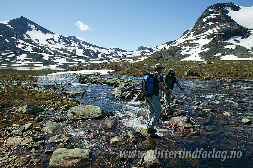 Elva fra Høgvagltjønnen ned mot Langvatnet steingås. Dette er en del av ruta mellom Leirvassbu og Olavsbu. Bak til venstre ses Skarddalstinden (2100 moh).